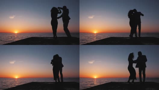 年轻的西班牙夫妇的剪影在夕阳下的大海背景。男人和女人跳舞拉丁美洲的感官舞蹈:bachata, salsa或kizomba。慢动作高清在线视频素材下载