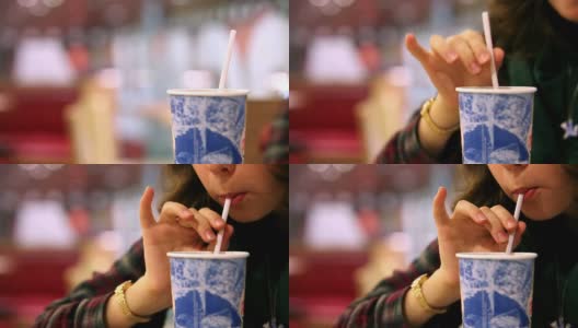快餐店:女孩用吸管喝冷饮高清在线视频素材下载