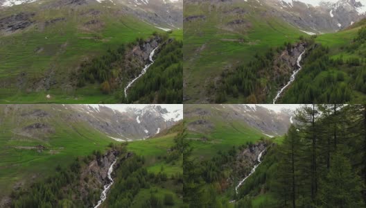空中:飞越高山峡谷，风景如画的瀑布，雪山山脉和戏剧性的道路高清在线视频素材下载