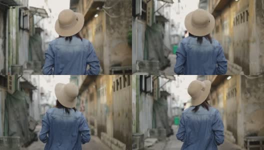 年轻的亚洲女性旅行者的肖像戴着复古软呢帽走在泰国曼谷的一条小街上。享受暑假旅行。单独旅行的概念。高清在线视频素材下载