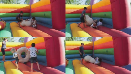 在公园里，孩子们在彩色的蹦床上蹦蹦跳跳高清在线视频素材下载