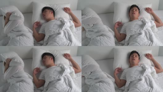 年轻的亚洲男人在床上睡觉时打鼾。高清在线视频素材下载