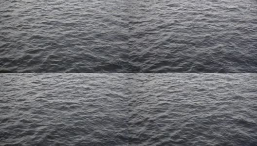 黑色的水和黑色的波浪在海洋或海面上。黑暗，阴沉的海与云波和水面上的波纹的背景。高清在线视频素材下载