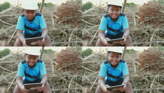 小男孩亚洲与工程师帽一个使用数字表，概念我的梦想工程师，慢动作高清在线视频素材下载