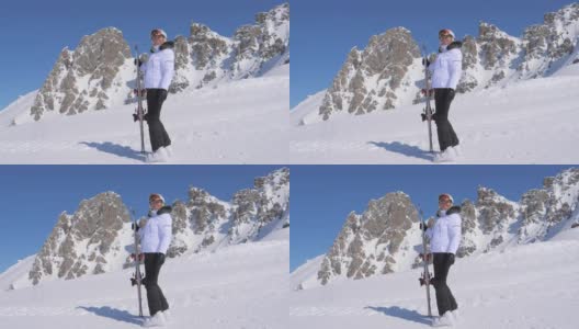 女子滑雪者手持滑雪板站在山的一侧高清在线视频素材下载