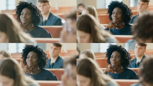 聪明美丽的年轻黑人女孩在一间满是多民族学生的教室里听讲座。浅景深。高清在线视频素材下载