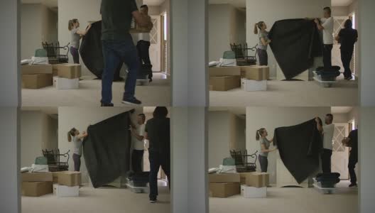 女人和男人用移动的毯子覆盖家具高清在线视频素材下载