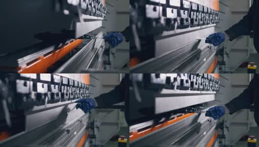 工人在工厂的现代弯曲工业机器上弯曲金属板。高清在线视频素材下载