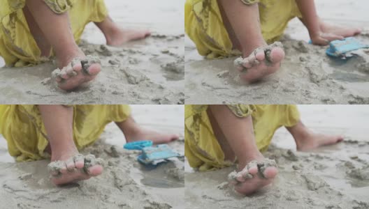 光着脚的小女孩在沙滩上玩沙子的慢镜头高清在线视频素材下载