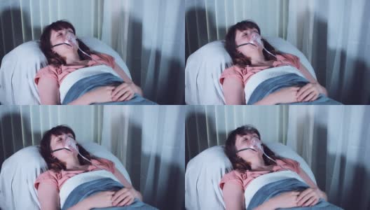 4k医院拍摄的带着氧气面罩睡觉的女病人和冒出来的烟高清在线视频素材下载