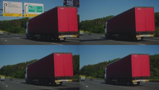 带着货物拖车的半挂车行驶在公路上。卡车是白色的，货运拖车是红色的。使用黑魔法袖珍电影相机6K拍摄高清在线视频素材下载