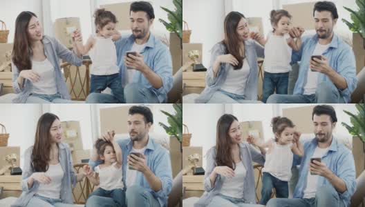 一家人和女儿一起跳舞唱歌，搬到新家时和孩子一起用智能手机，慢动作，4K分辨率。高清在线视频素材下载