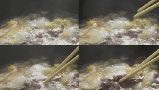 用电锅将煮熟的切片牛肉涮锅或寿喜烧和鸡蛋配蔬菜汤高清在线视频素材下载
