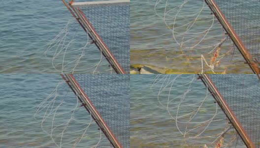 在靠近礁石的港口一侧的铁丝网高清在线视频素材下载