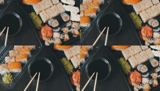 在时尚的黑色背景上，配有各种寿司卷、寿司卷、手握寿司、粗看寿司。酱油和竹筷就在旁边高清在线视频素材下载
