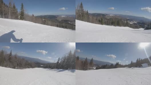在阳光明媚的天气里，滑雪者沿着斜坡快速地滑下滑雪道高清在线视频素材下载
