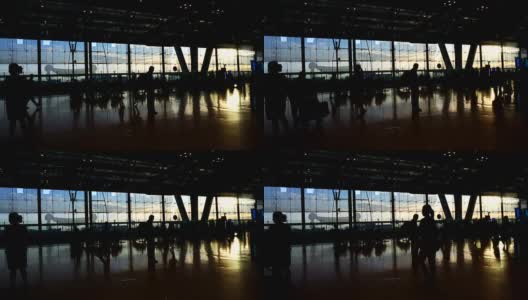 在机场，人群的剪影与晨光玻璃建筑形成对比高清在线视频素材下载