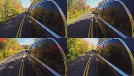 近距离观察:一辆黑色汽车在阳光明媚的秋天里穿过五颜六色的秋天森林高清在线视频素材下载