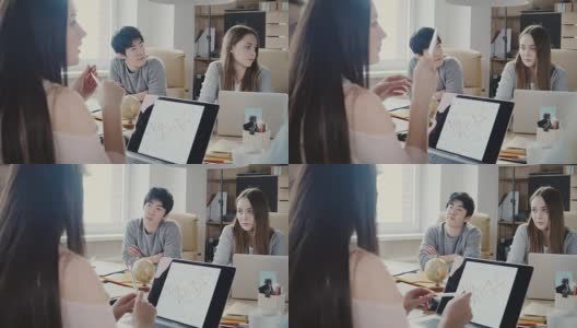 一个严肃的亚洲年轻人和一个白人女孩坐在办公室会议桌旁。混血商人讨论4K高清在线视频素材下载