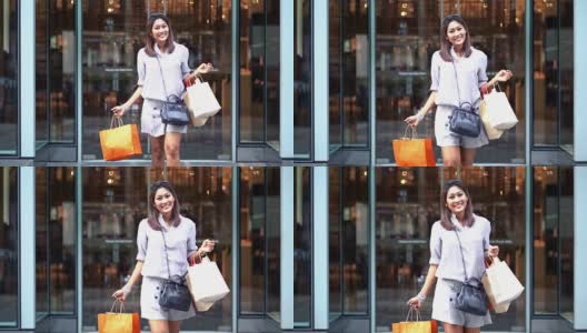 4K慢镜头的亚洲女人走出百货商店，拿着购物袋在市中心，时尚和购物中心的概念高清在线视频素材下载