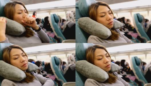 4K特写镜头:一名亚洲女子在飞机上打哈欠。对长途战斗感到厌倦高清在线视频素材下载