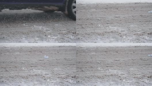 在下雪的白天，汽车在雪道上高速行驶。烂泥和泥土都飞走了。地面湿滑。车轮在慢动作的特写。恶劣的天气导致交通堵塞，暴风雪高清在线视频素材下载