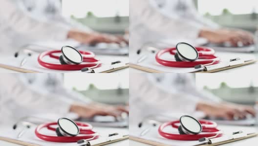 红色听诊器在医疗文件的背景下医生在电脑上工作高清在线视频素材下载
