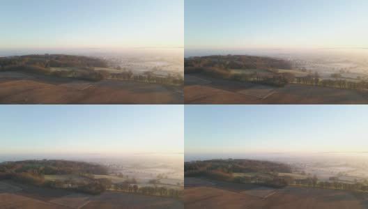 无人机拍摄的广阔的雾蒙蒙的乡村景观在日出高清在线视频素材下载