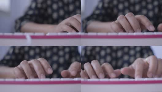 一个女人的双手在桌子上敲击键盘。高清在线视频素材下载