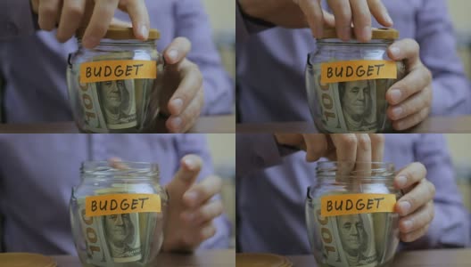 一个白人男人把一个玻璃罐放在抽屉里和他未来的预算高清在线视频素材下载