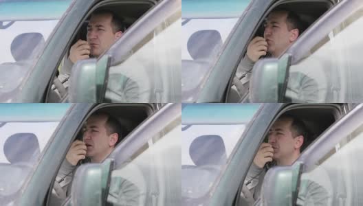 一个男人在他的车里拿着麦克风，用收音机讲话。高清在线视频素材下载