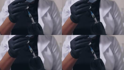 近距离观看一个不认识的专业医生在黑色手套和口罩与医疗注射器在手中，准备注射高清在线视频素材下载