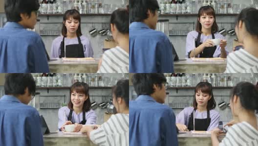 在一家当地的咖啡店里，一位漂亮的女咖啡师正在为一位女顾客点单高清在线视频素材下载