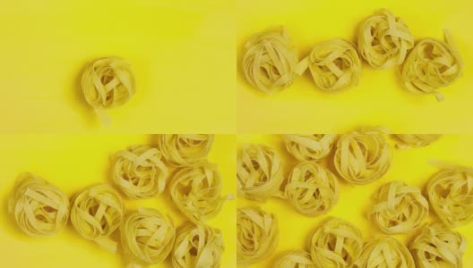 一个生的，干燥的意大利面停止运动。亮黄色背景上的意大利面特写。高清在线视频素材下载