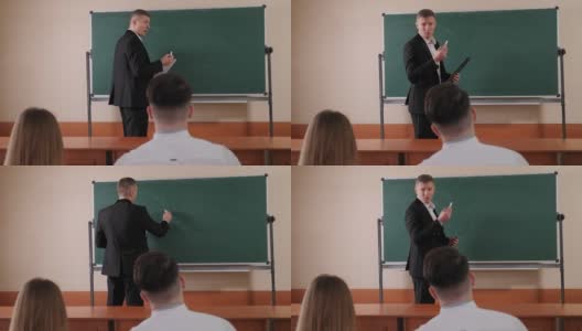 大学里的老师站在黑板旁边和学生们谈话。高清在线视频素材下载