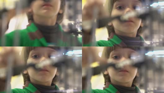 可爱的小男孩看着复杂的迷宫和小弹珠通过高清在线视频素材下载