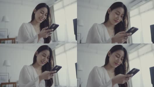 微笑的年轻女子使用手机高清在线视频素材下载