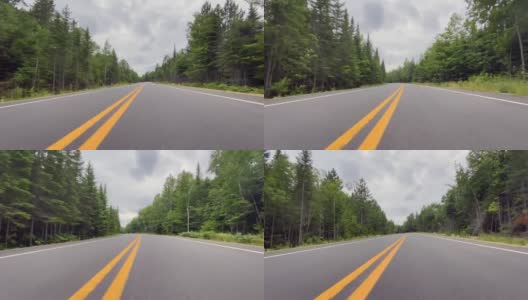 一辆汽车在加拿大魁北克的山林路上行驶的视频高清在线视频素材下载