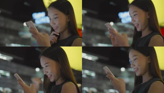 年轻的亚洲女人在晚上用手机高清在线视频素材下载