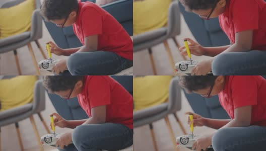 聪明的小男孩用螺丝刀修理坏了的玩具车，技能发展高清在线视频素材下载