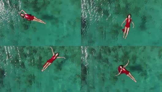 一个女人在热带海洋上漂浮和游泳的无人机视图高清在线视频素材下载