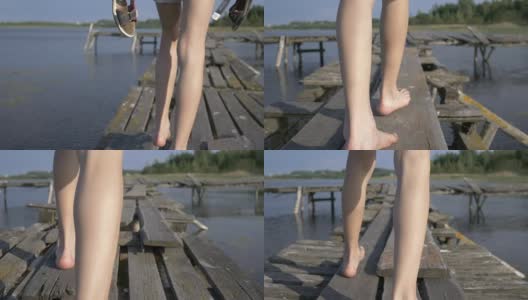 男孩光着脚走在码头上，手里拿着拖鞋高清在线视频素材下载