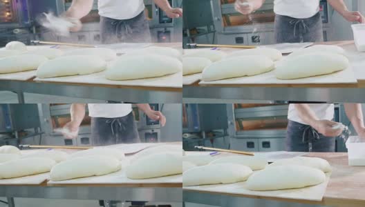 烘焙师在烘焙前将面粉洒在生面包上高清在线视频素材下载
