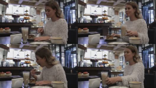 好女孩在咖啡馆吃美味高清在线视频素材下载