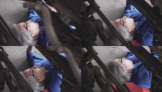 俯视图:亚洲高级汽车技师在车下工作的头像高清在线视频素材下载