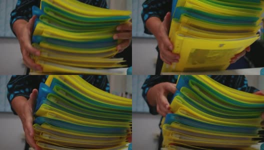 亚洲女商人手里拿着许多文件成堆的文件夹在办公室里存放年度报告文件，成堆的彩色文件夹关年度预算，业务繁忙的概念。高清在线视频素材下载