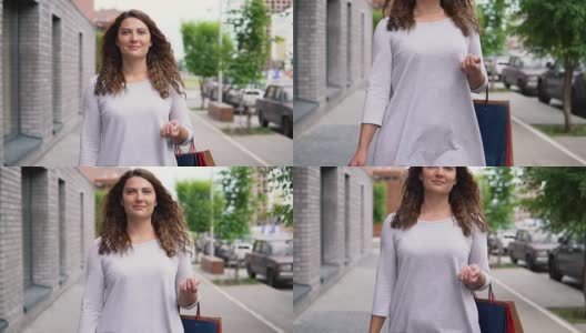 一个女孩穿着一件轻薄的长裙，留着长发，购物后心情很好地走在街上，手里拿着一大包东西。缓慢的运动。高清高清在线视频素材下载
