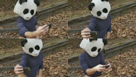 一名男子戴着熊猫面具用手机给自己拍照高清在线视频素材下载