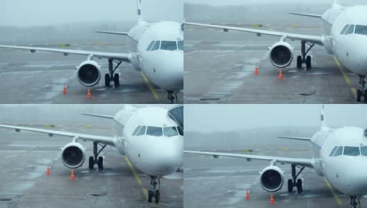 拍摄:恶劣天气飞机在国际机场起飞前与登机桥对接高清在线视频素材下载