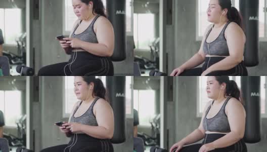 一个年轻女人在健身房里戴着耳机说话高清在线视频素材下载